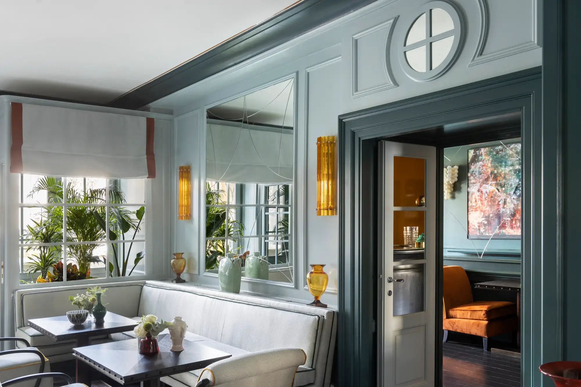 Elegant teal restaurant dining room with sophisticated table settings and modern Italian design